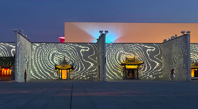 The façade of a building with white swirls projected onto it.